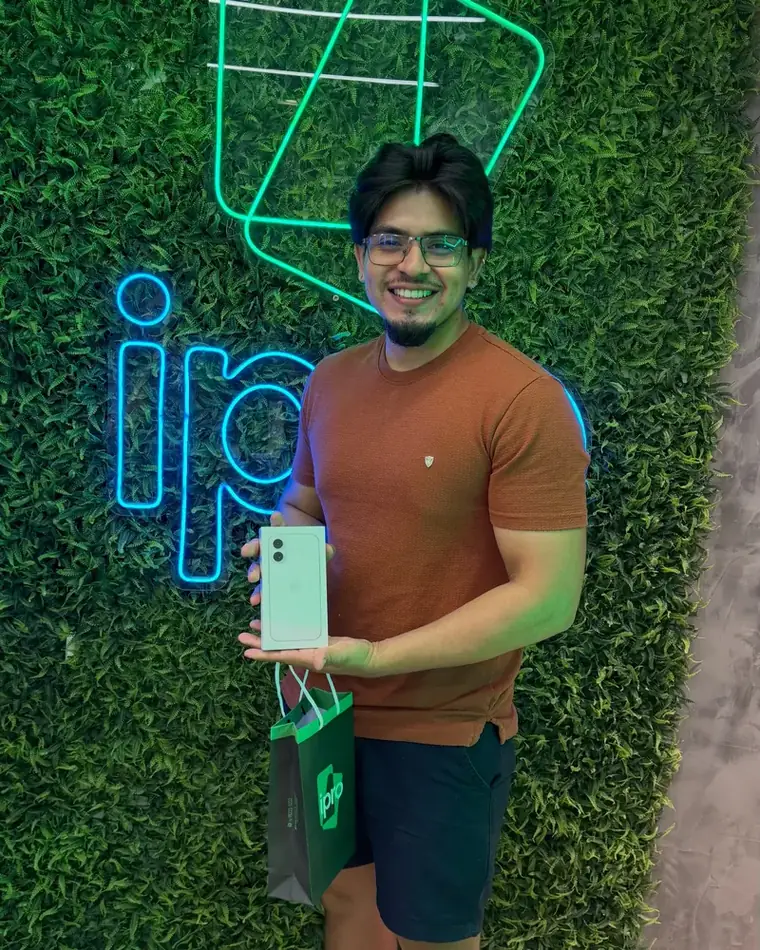 Cliente com iPhone novo na parede de neon